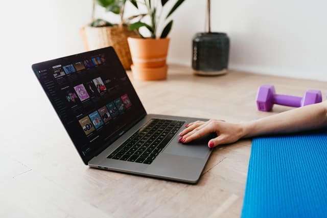 A woman using a laptop while exercising.