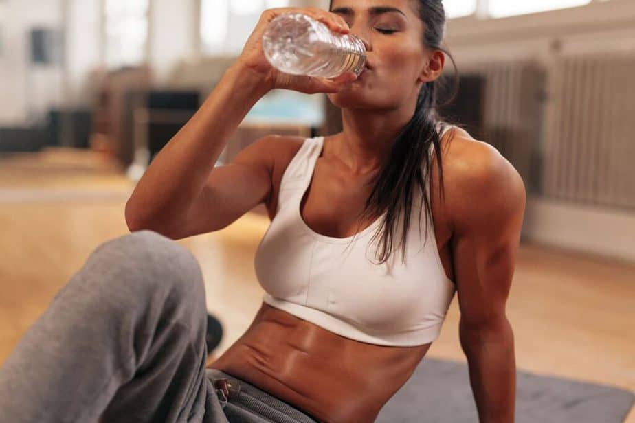 10 Most Common Fitness Mistakes Women Make In The Gym - woman drinking water at the gym.
